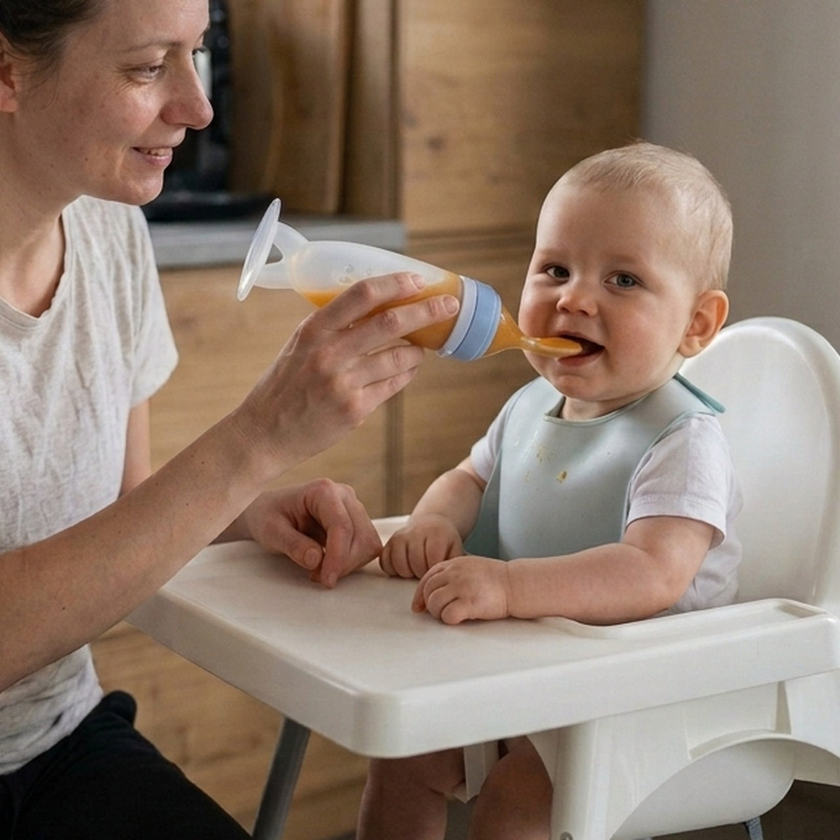 Mother feeding her baby with the Nomly squeeze spoon feeder